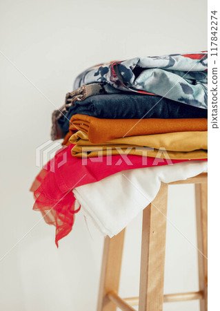 arrangement of fabrics on a wooden stool, blend of traditional craftsmanship with contemporary design aesthetics 117842274