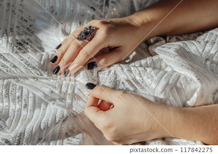 hand holding lavishly designed white fabric, capturing fine details and luxurious quality that define high-end fashion 117842275