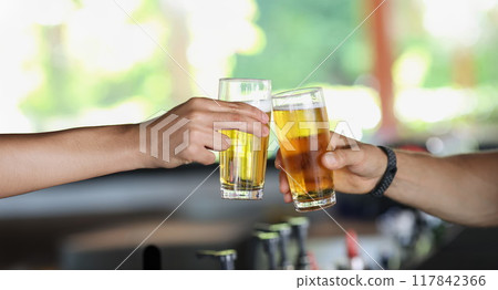 Male hands with glasses of beer clink glasses 117842366