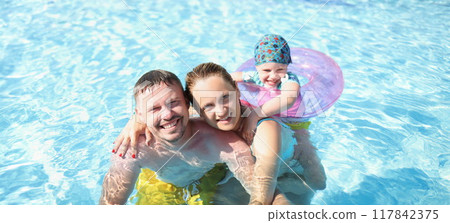 Husband with wife and child swim together in the pool Husband with wife and child swim together in the pool 117842375