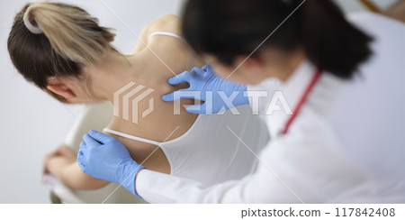 Chiropractor doctor presses on a woman's spine Chiropractor doctor presses on a woman's spine 117842408