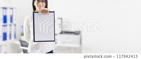 Woman in the office shows a folder with a document, mock up Woman in the office shows a folder with a document, mock up 117842413