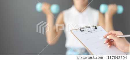 Female hands are writing down a workout plan, motivation Female hands are writing down a workout plan, motivation 117842504