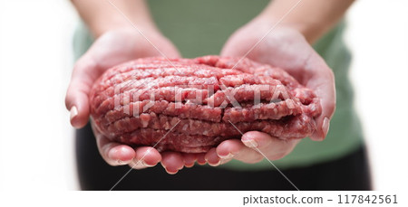 There is a lot of fresh red fat mince in female hands There is a lot of fresh red fat mince in female hands 117842561