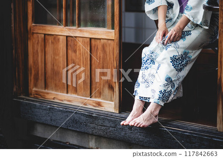 A young woman in a yukata sitting on the veranda A young woman in a yukata sitting on the veranda 117842663