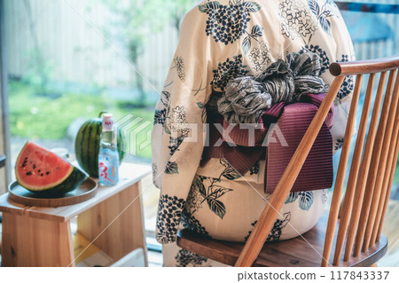 A woman in a yukata eating watermelon 117843337