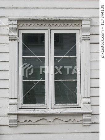 Beautiful old window of a white timber house in Stavanger, Norway. Beautiful old window of a white timber house in Stavanger, Norway. 117844139