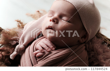 Newborn, Adorably Swaddled In A Blanket And Wearing A Hat, Sleeps Peacefully 117844524