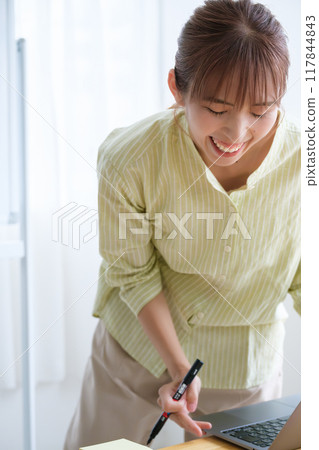 A young woman visualizing issues in the office 117844843