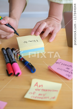 A young woman visualizing issues in the office 117844844