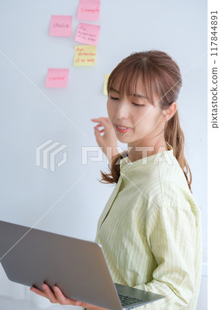 A young woman visualizing issues in the office A young woman visualizing issues in the office 117844891