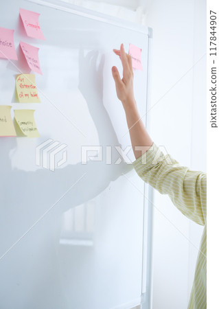 A young woman visualizing issues in the office A young woman visualizing issues in the office 117844907