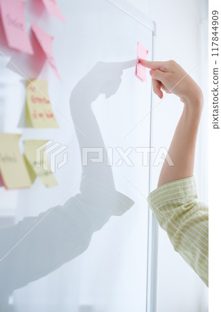 A young woman visualizing issues in the office 117844909