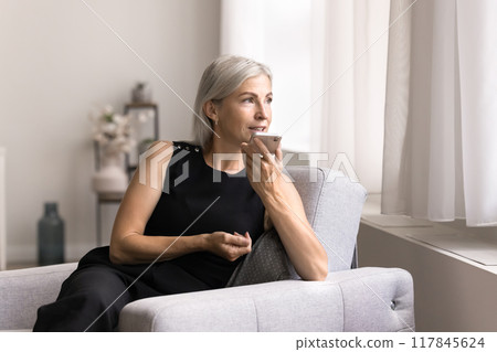 Mature woman holding smartphone recording audio message to friend Mature woman holding smartphone recording audio message to friend 117845624