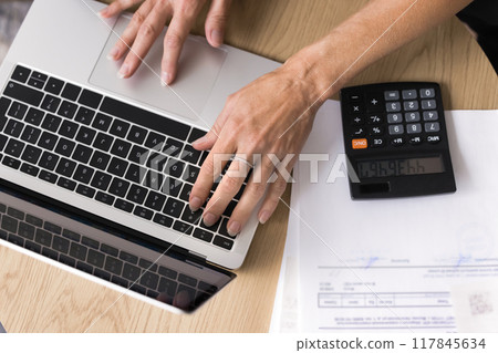 Closeup top view accounting female working on laptop Closeup top view accounting female working on laptop 117845634