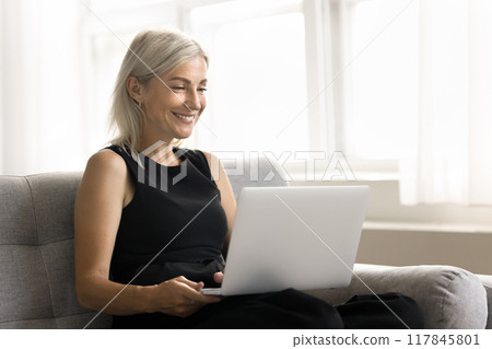 Woman using laptop watch online movie through digital streaming services 117845801