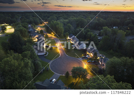 Upscale suburban homes at sunset with large backyards and green grassy lawns. Illuminated private residential houses in rural suburban sprawl area in Rochester, New York Upscale suburban homes at sunset with large backyards and green grassy lawns. Illuminated private residential houses in rural suburban sprawl area in Rochester, New York 117846222