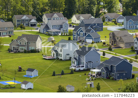 Upscale suburban homes with large backyards and green grassy lawns in summer season. Private residential houses in rural suburban sprawl area in Rochester, New York Upscale suburban homes with large backyards and green grassy lawns in summer season. Private residential houses in rural suburban sprawl area in Rochester, New York 117846223