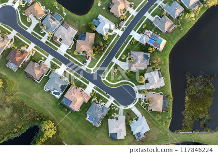 Upscale suburban homes with large backyards and green grassy lawns. Private residential houses in rural suburban sprawl area in Sarasota, Florida 117846224