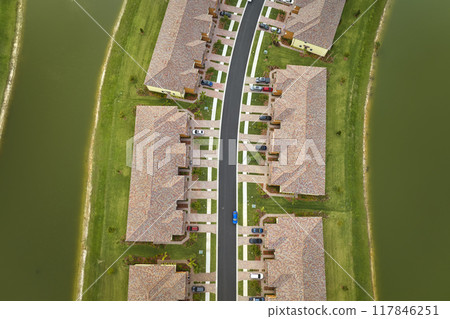 View from above of densely built residential houses near retention ponds in closed living clubs in south Florida. American dream homes as example of real estate development in US suburbs View from above of densely built residential houses near retention ponds in closed living clubs in south Florida. American dream homes as example of real estate development in US suburbs 117846251