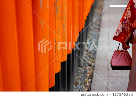 A woman in a kimono walking through Senbon Torii 117846350
