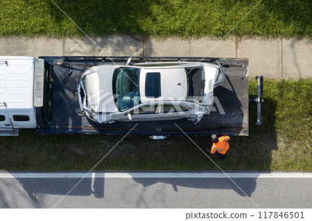 Traffic accident with tow truck hauling smashed vehicle on car crash site. First responders helping on road emergency in Florida, USA 117846501