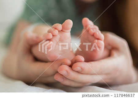 Happy family. Tiny newborn infant male or female baby feet on mother hands. Mother holding newborn child. Mom and her baby. Maternity tenderness parenthood new life concept. Handle with care 117846637