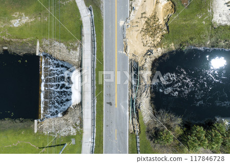 Repair of destroyed bridge after hurricane flood in Florida. Reconstruction of damaged road after flooding water washed away asphalt. Construction roadwork site Repair of destroyed bridge after hurricane flood in Florida. Reconstruction of damaged road after flooding water washed away asphalt. Construction roadwork site 117846728