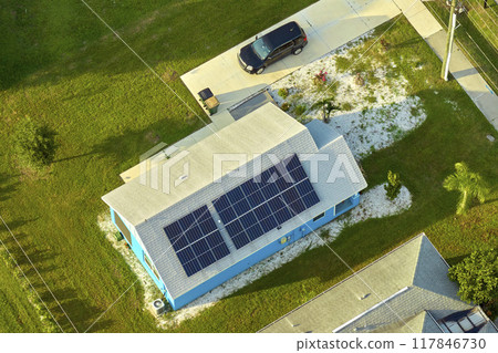 Residential house with rooftop covered with solar photovoltaic panels for producing of clean ecological electrical energy in suburban rural area. Concept of autonomous home 117846730