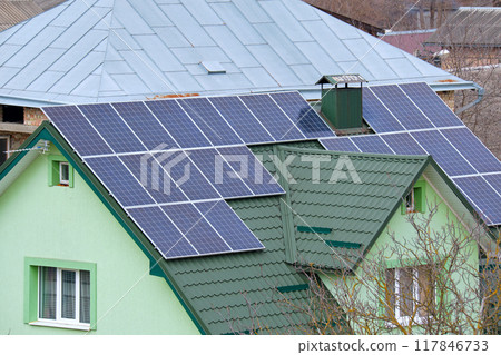 Residential house with rooftop covered with solar photovoltaic panels for producing of clean ecological electrical energy in suburban rural area. Concept of autonomous home Residential house with rooftop covered with solar photovoltaic panels for producing of clean ecological electrical energy in suburban rural area. Concept of autonomous home 117846733