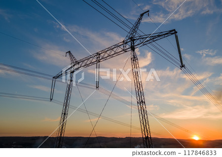 Dark silhouette of high voltage tower with electric power lines at sunrise. Transmission of electric energy concept Dark silhouette of high voltage tower with electric power lines at sunrise. Transmission of electric energy concept 117846833