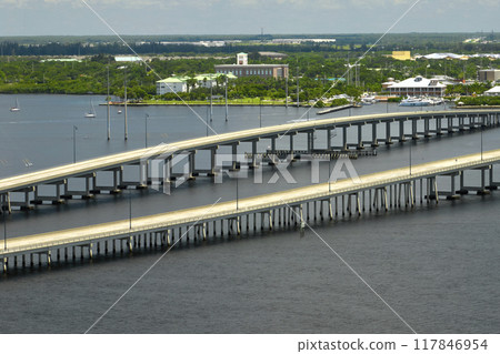 Barron Collier Bridge and Gilchrist Bridge in Florida with moving traffic. Transportation infrastructure in Charlotte County connecting Punta Gorda and Port Charlotte over Peace River 117846954