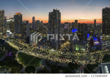 Brightly illuminated skyscraper buildings and traffic in downtown district of Miami Brickell in Florida, USA at night. American megapolis with business financial district Brightly illuminated skyscraper buildings and traffic in downtown district of Miami Brickell in Florida, USA at night. American megapolis with business financial district 117846994