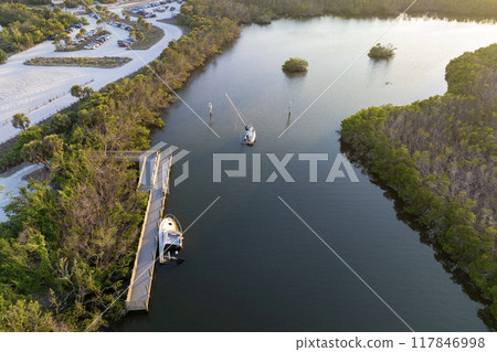Capsized sunken sailing boat left forsaken on shallow bay waters after hurricane Ian in Manasota, Florida 117846998