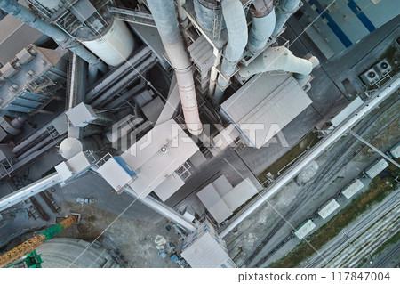 Cement plant with high factory structure and tower cranes at industrial production area. Manufacture and global industry concept 117847004