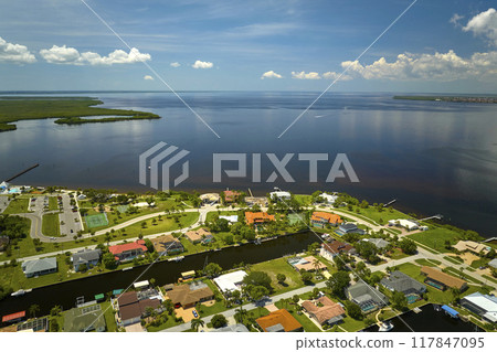 Aerial view of residential suburbs with private homes located on gulf coast near wildlife wetlands with green vegetation on sea shore. Living close to nature concept Aerial view of residential suburbs with private homes located on gulf coast near wildlife wetlands with green vegetation on sea shore. Living close to nature concept 117847095