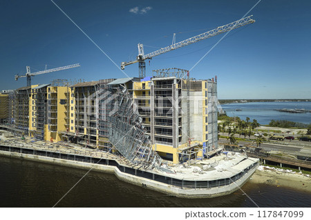 Aerial view of ruined by hurricane Ian construction scaffolding on high apartment building site in Port Charlotte, USA 117847099