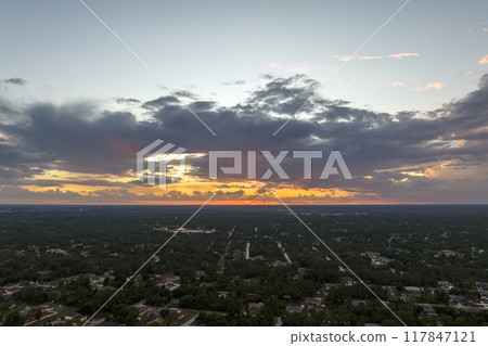 Aerial view of suburban landscape with private homes between green palm trees in Florida quiet residential area in evening 117847121