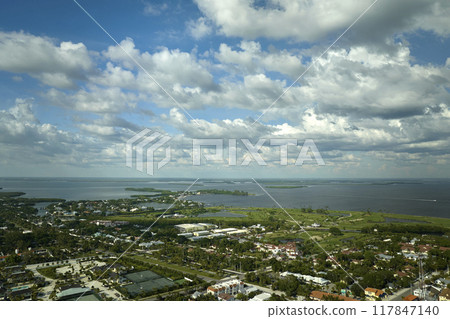 Aerial view of wealthy waterfront neighborhood. Expensive mansions between green palm trees on Gulf of Mexico shore in island small town Boca Grande on Gasparilla Island in southwest Florida, USA 117847140