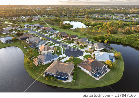 American dream homes at evening on rural cul-de-sac street in US suburbs. View from above of waterfront residential houses in living area in North Port, Florida American dream homes at evening on rural cul-de-sac street in US suburbs. View from above of waterfront residential houses in living area in North Port, Florida 117847160