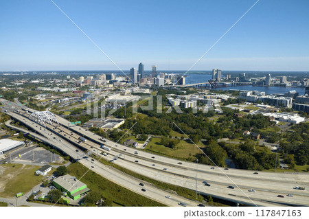American freeway intersection with fast driving cars and trucks. View from above of USA transportation infrastructure American freeway intersection with fast driving cars and trucks. View from above of USA transportation infrastructure 117847163