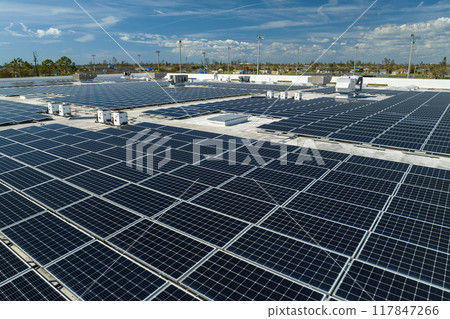 Aerial view of blue photovoltaic solar panels mounted on industrial building roof for producing green ecological electricity. Production of sustainable energy concept Aerial view of blue photovoltaic solar panels mounted on industrial building roof for producing green ecological electricity. Production of sustainable energy concept 117847266