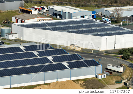 Aerial view of blue photovoltaic solar panels mounted on industrial building roof for producing green ecological electricity. Production of sustainable energy concept 117847267