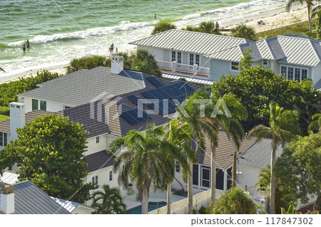 Aerial view of expensive american home roof with blue solar photovoltaic panels for producing clean ecological electric energy. Investing in renewable electricity for retirement income 117847302