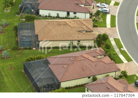 Aerial view of expensive modern houses with outside swimming pool covered with mosquito mesh on metal frame for insect protection in Florida closed living club 117847304