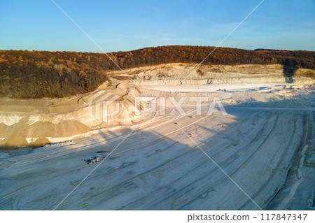 Aerial view of open pit mine of sandstone materials for construction industry with excavators and dump trucks. Heavy equipment in mining and production of useful minerals concept Aerial view of open pit mine of sandstone materials for construction industry with excavators and dump trucks. Heavy equipment in mining and production of useful minerals concept 117847347