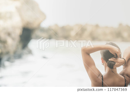 年輕女子把頭髮綁在海灘上 117847369