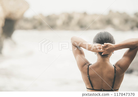 年輕女子把頭髮綁在海灘上 年輕女子把頭髮綁在海灘上 117847370