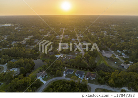Aerial landscape view of suburban private houses between green palm trees in Florida quiet rural area at sunset Aerial landscape view of suburban private houses between green palm trees in Florida quiet rural area at sunset 117847388