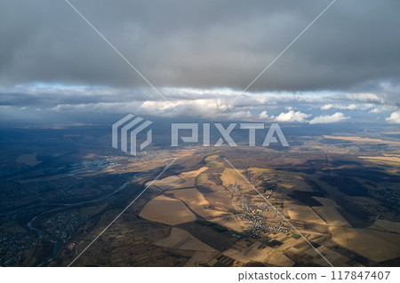 Aerial view from high altitude of earth covered with puffy rainy clouds forming before rainstorm Aerial view from high altitude of earth covered with puffy rainy clouds forming before rainstorm 117847407
